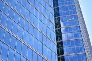 moderno oficina edificio con vaso fachada en un claro cielo antecedentes. transparente vaso pared de oficina edificio. foto