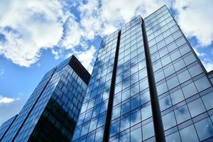 Modern office building with glass facade on a clear sky background. Transparent glass wall of office building. photo