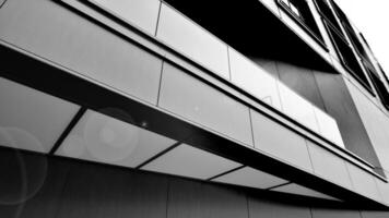 A view at a straight facade of a modern building with a dark grey facade. Dark grey metallic panel facad. Modern architectural details. Black and white. photo