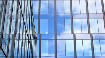 moderno oficina edificio con vaso fachada en un claro cielo antecedentes. transparente vaso pared de oficina edificio. foto