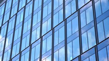 Modern office building with glass facade on a clear sky background. Transparent glass wall of office building. photo