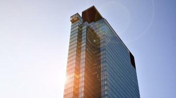 Modern office building with glass facade on a clear sky background. Transparent glass wall of office building. photo