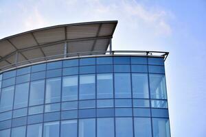 Modern office building with glass facade on a clear sky background. Transparent glass wall of office building. photo