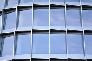 moderno oficina edificio con vaso fachada en un claro cielo antecedentes. transparente vaso pared de oficina edificio. foto