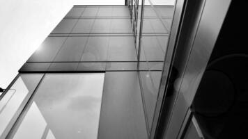 A view at a straight facade of a modern building with a dark grey facade. Dark grey metallic panel facad. Modern architectural details. Black and white. photo