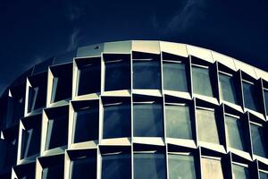 Modern office building with glass facade on a clear sky background. Transparent glass wall of office building. photo