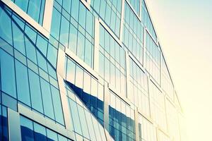 Modern office building with glass facade on a clear sky background. Transparent glass wall of office building. photo