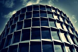 Modern office building with glass facade on a clear sky background. Transparent glass wall of office building. photo