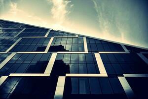 Modern office building with glass facade on a clear sky background. Transparent glass wall of office building. photo