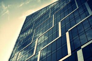 Modern office building with glass facade on a clear sky background. Transparent glass wall of office building. photo