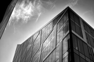 Modern office building with glass facade on a clear sky background. Transparent glass wall of office building. photo