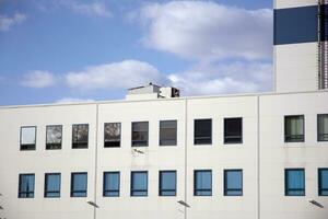 A view at a straight facade of a modern building with a dark grey facade. Dark grey metallic panel facad. Modern architectural details. photo