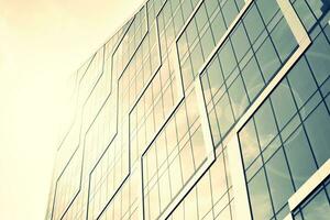 Modern office building with glass facade on a clear sky background. Transparent glass wall of office building. photo