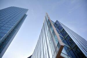 Glass building with transparent facade of the building and blue sky. Structural glass wall reflecting blue sky. Abstract modern architecture fragment. Contemporary architectural background. photo