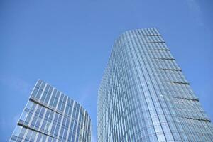 Glass building with transparent facade of the building and blue sky. Structural glass wall reflecting blue sky. Abstract modern architecture fragment. Contemporary architectural background. photo