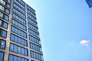 Glass building with transparent facade of the building and blue sky. Structural glass wall reflecting blue sky. Abstract modern architecture fragment. Contemporary architectural background. photo