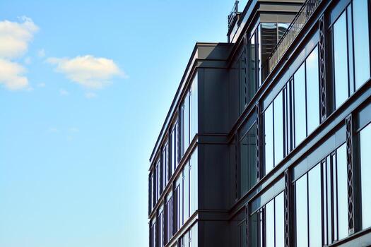 Glass building with transparent facade of the building and blue sky. Structural glass wall reflecting blue sky. Abstract modern architecture fragment. Contemporary architectural background. photo