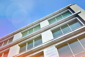 Glass building with transparent facade of the building and blue sky. Structural glass wall reflecting blue sky. Abstract modern architecture fragment. Contemporary architectural background. photo