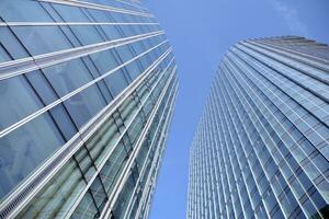 Glass building with transparent facade of the building and blue sky. Structural glass wall reflecting blue sky. Abstract modern architecture fragment. Contemporary architectural background. photo
