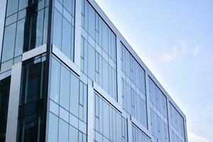 vaso edificio con transparente fachada de el edificio y azul cielo. estructural vaso pared reflejando azul cielo. resumen moderno arquitectura fragmento. contemporáneo arquitectónico antecedentes. foto