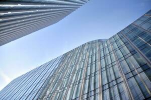 Glass building with transparent facade of the building and blue sky. Structural glass wall reflecting blue sky. Abstract modern architecture fragment. Contemporary architectural background. photo