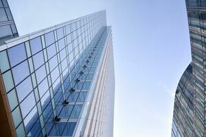 vaso edificio con transparente fachada de el edificio y azul cielo. estructural vaso pared reflejando azul cielo. resumen moderno arquitectura fragmento. contemporáneo arquitectónico antecedentes. foto