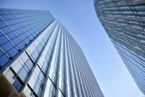 Glass building with transparent facade of the building and blue sky. Structural glass wall reflecting blue sky. Abstract modern architecture fragment. Contemporary architectural background. photo