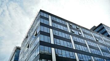 Glass building with transparent facade of the building and blue sky. Structural glass wall reflecting blue sky. Abstract modern architecture fragment. Contemporary architectural background. photo