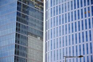 Glass building with transparent facade of the building and blue sky. Structural glass wall reflecting blue sky. Abstract modern architecture fragment. Contemporary architectural background. photo