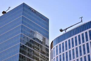 Glass building with transparent facade of the building and blue sky. Structural glass wall reflecting blue sky. Abstract modern architecture fragment. Contemporary architectural background. photo