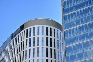 Glass building with transparent facade of the building and blue sky. Structural glass wall reflecting blue sky. Abstract modern architecture fragment. Contemporary architectural background. photo