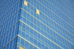 Glass building with transparent facade of the building and blue sky. Structural glass wall reflecting blue sky. Abstract modern architecture fragment. Contemporary architectural background. photo