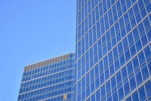 Glass building with transparent facade of the building and blue sky. Structural glass wall reflecting blue sky. Abstract modern architecture fragment. Contemporary architectural background. photo