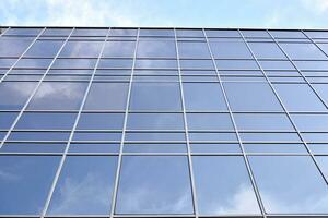 vaso edificio con transparente fachada de el edificio y azul cielo. estructural vaso pared reflejando azul cielo. resumen moderno arquitectura fragmento. contemporáneo arquitectónico antecedentes. foto