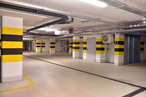 Departure from the underground garage with white gate. Interior pillars painted yellow. photo