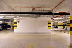 Departure from the underground garage with white gate. Interior pillars painted yellow. photo