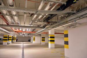 Departure from the underground garage with white gate. Interior pillars painted yellow. photo