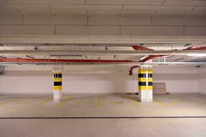 Departure from the underground garage with white gate. Interior pillars painted yellow. photo