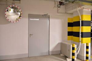 Departure from the underground garage with white gate. Interior pillars painted yellow. photo