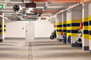 Departure from the underground garage with white gate. Interior pillars painted yellow. photo