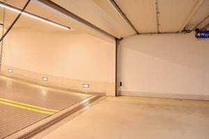 Departure from the underground garage with white gate. Interior pillars painted yellow. photo