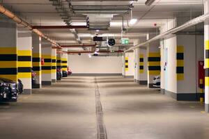 Departure from the underground garage with white gate. Interior pillars painted yellow. photo