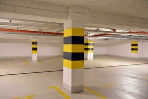 Departure from the underground garage with white gate. Interior pillars painted yellow. photo