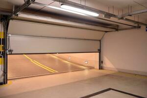 Departure from the underground garage with white gate. Interior pillars painted yellow. photo