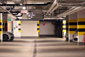 Departure from the underground garage with white gate. Interior pillars painted yellow. photo