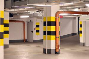 Departure from the underground garage with white gate. Interior pillars painted yellow. photo