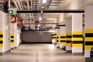 Departure from the underground garage with white gate. Interior pillars painted yellow. photo