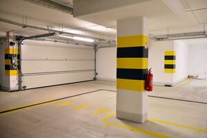 Departure from the underground garage with white gate. Interior pillars painted yellow. photo