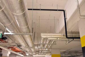 Sanitary system pipes and electrical cables installed under flat slab reinforced concrete structure in building. photo