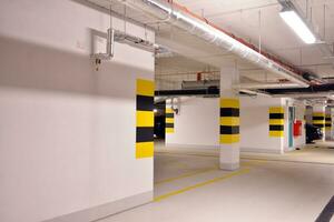 Departure from the underground garage with white gate. Interior pillars painted yellow. photo